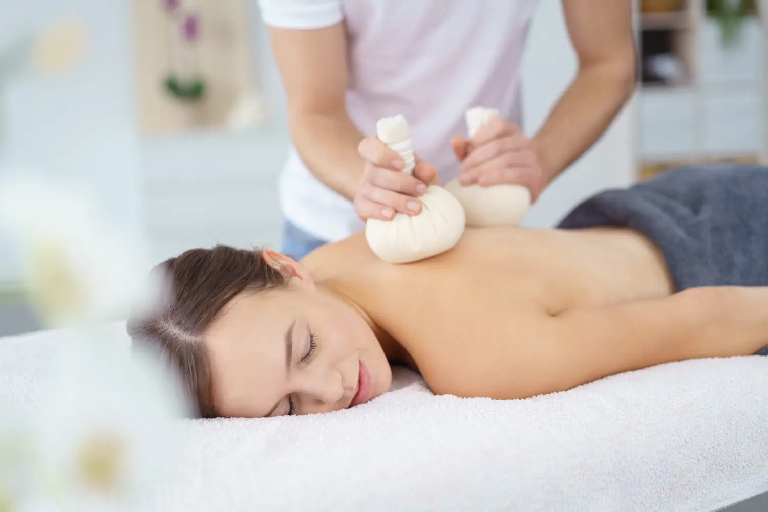 eine entspannende Massage mit Kräuterstempeln